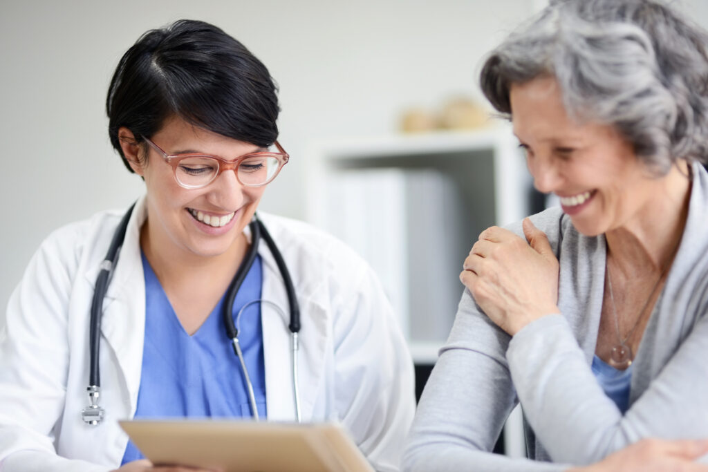 Medical professional smiles while showing information to a patient.