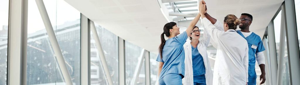 Health professionals engaged in a group high-five.