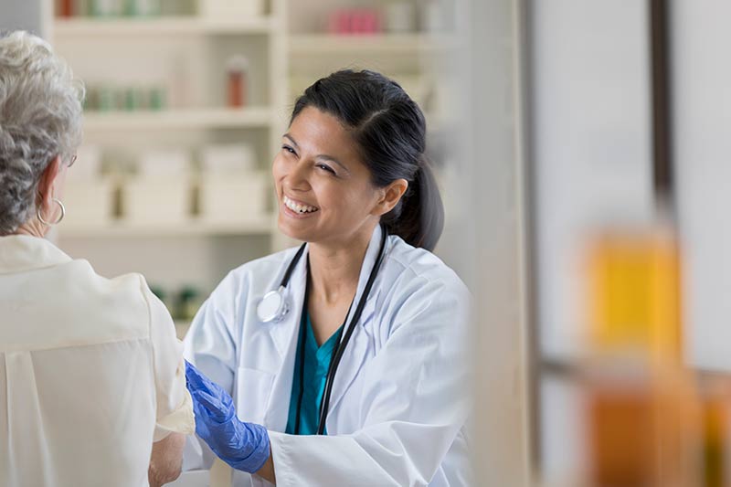 Smiling medical professional tending to patient.