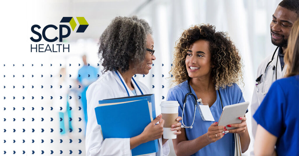 Medical professionals smiling while talking in a group.