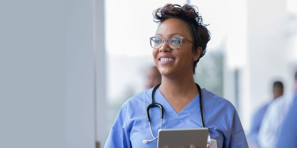 Smiling nurse holding a tablet.