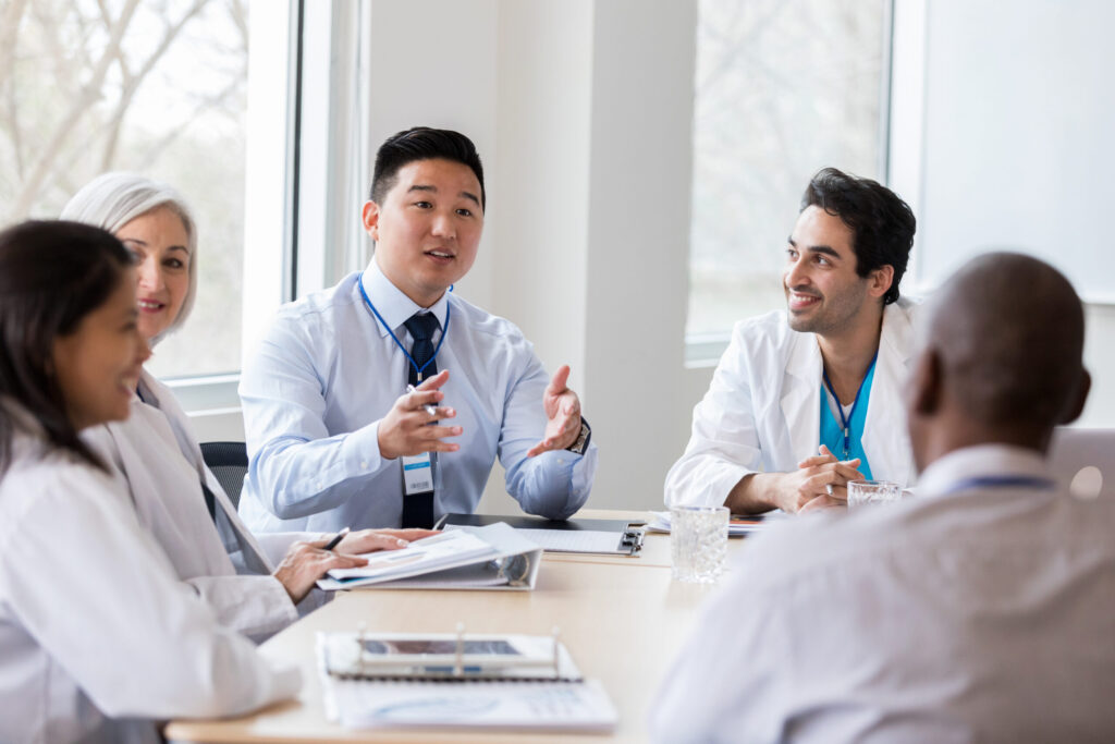 Medical professional speaking to their colleagues in a meeting.